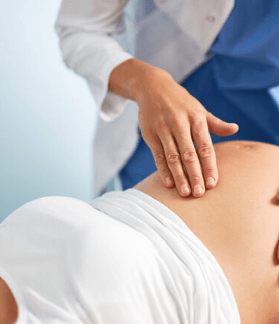 Obstetrician examining a pregnant woman before vacuum-assisted delivery